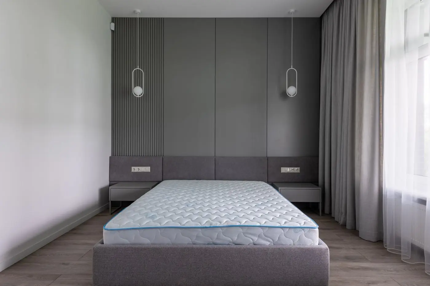 Tấm nệm mới đặt trên khung giường trong phòng ngủ tối giản
