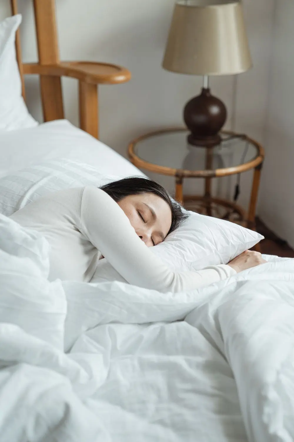Cô gái ngủ say trên giường chăn gối trắng
